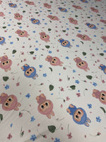Cute cartoon animal print fabric with pink and blue characters and small floral accents on a white background
