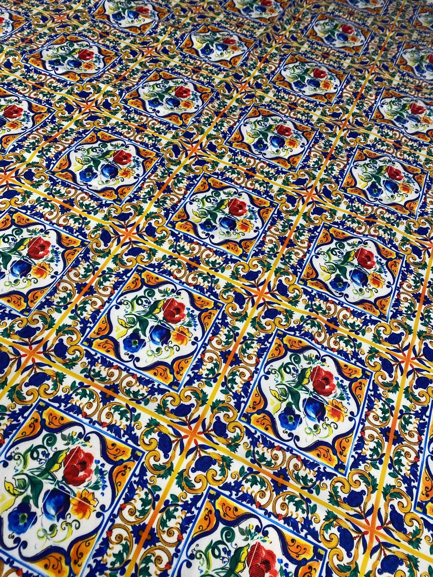 Ceramic design upholstery fabric with colorful floral tile pattern in blue, orange, green, and red on polyester material