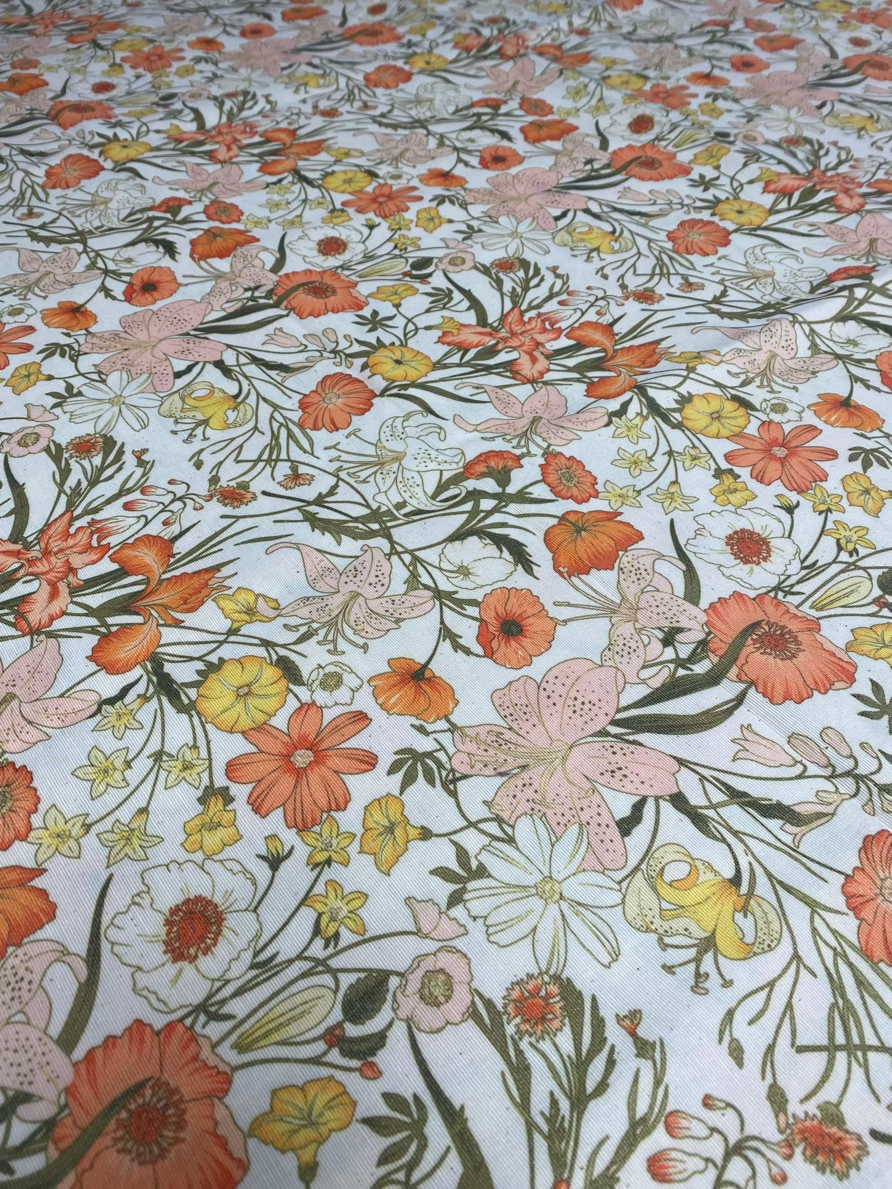 Orange floral patterned linen fabric with vibrant flowers for sewing and crafting projects