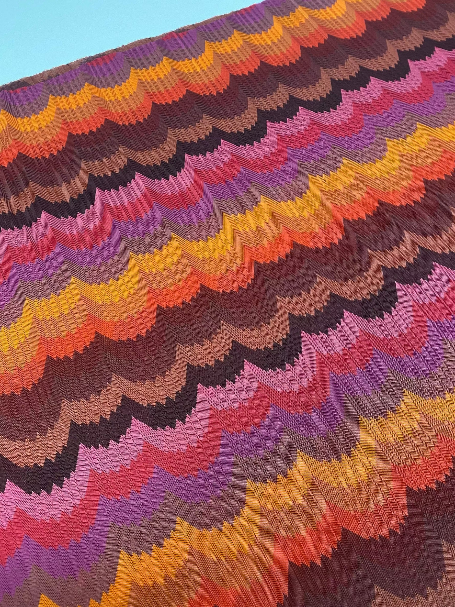 Colorful chevron zigzag mesh fabric with vibrant orange, purple, pink, and brown hues for crafting and fashion projects