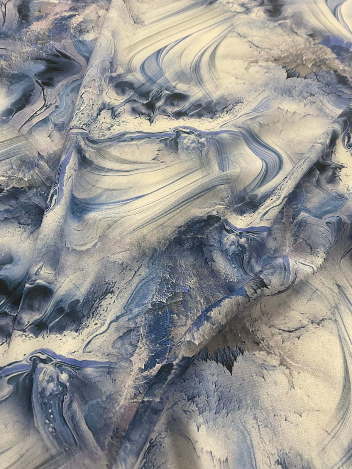 Abstract marble effect fabric with swirling blue and white patterns, high-quality material for upholstery, clothing, and crafts.