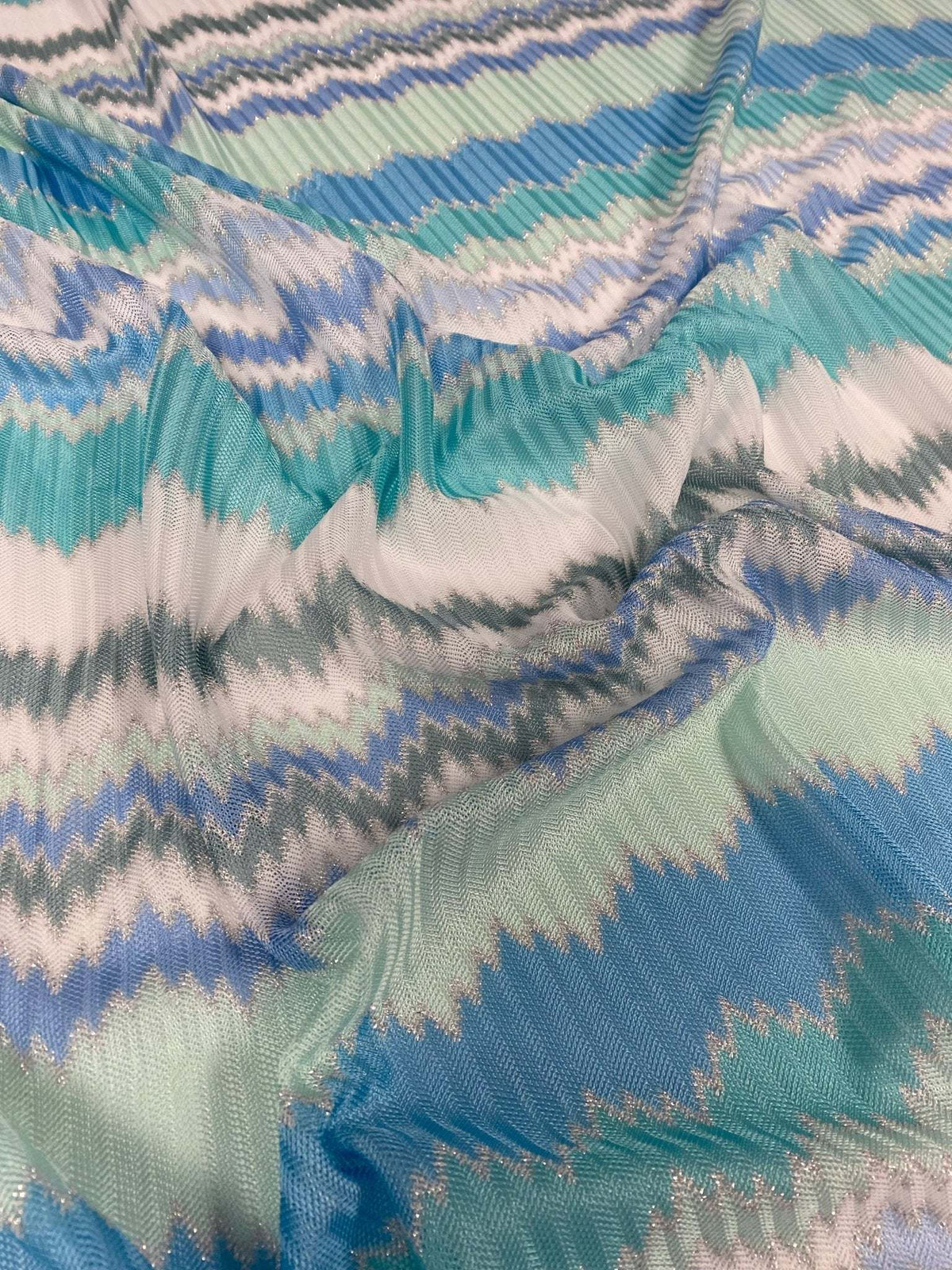 Aqua blue and mint green zigzag pattern woven fabric in knit mesh texture for versatile sewing projects