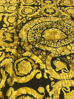 Baroque black and gold ornate upholstery fabric with intricate floral and decorative patterns.