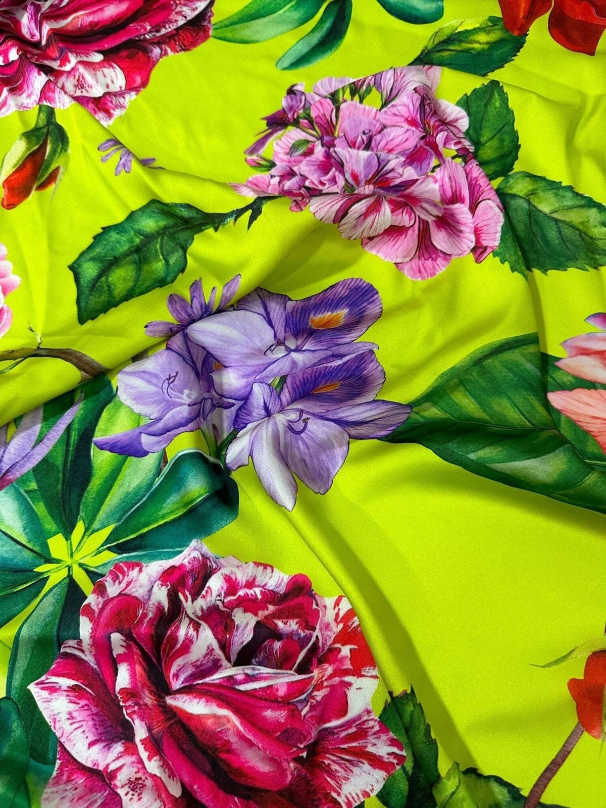 Floral neon green fabric with large rose and flower patterns on vibrant background