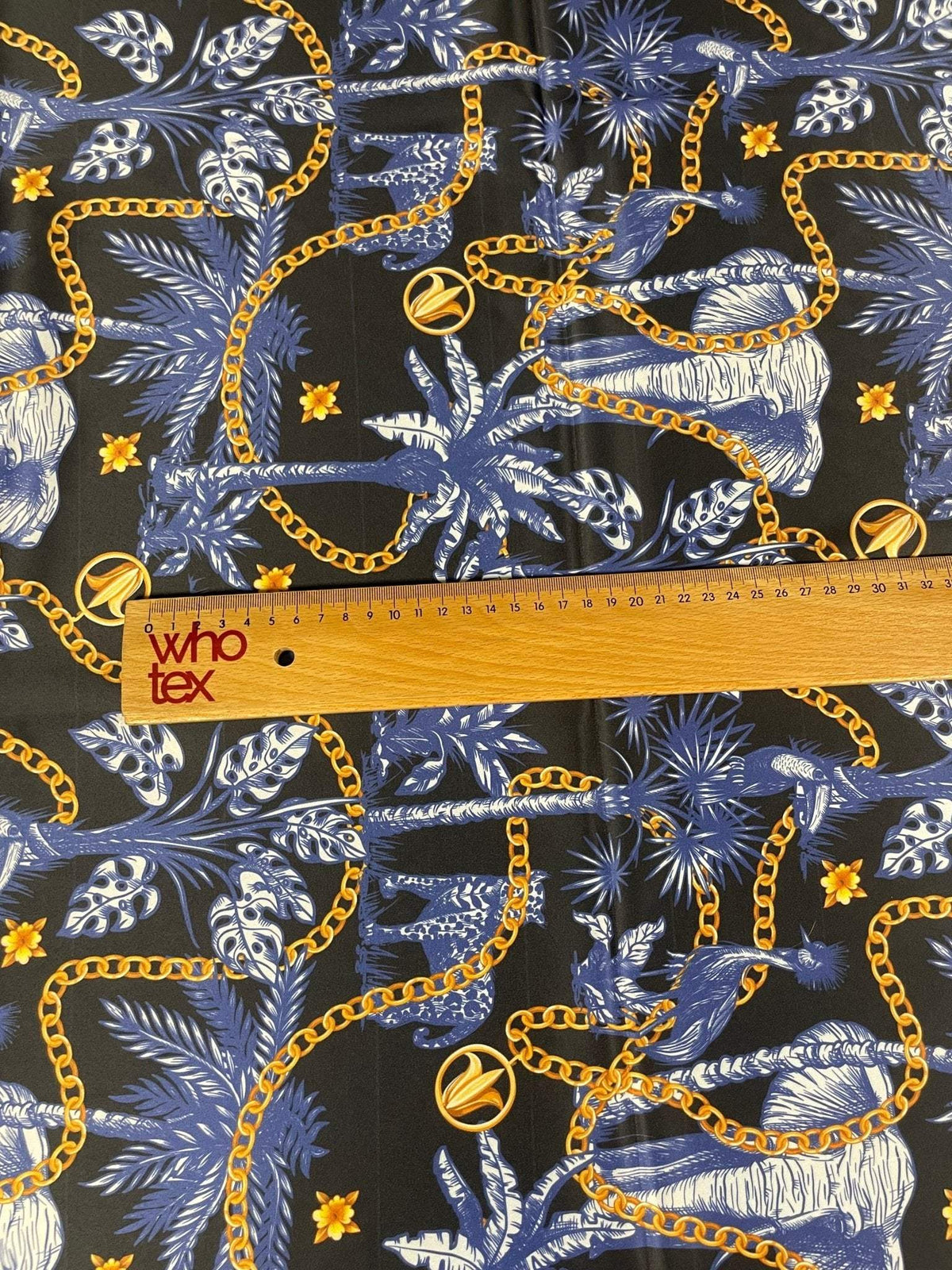 Black and blue tropical fabric with gold chain pattern and tropical leaves design