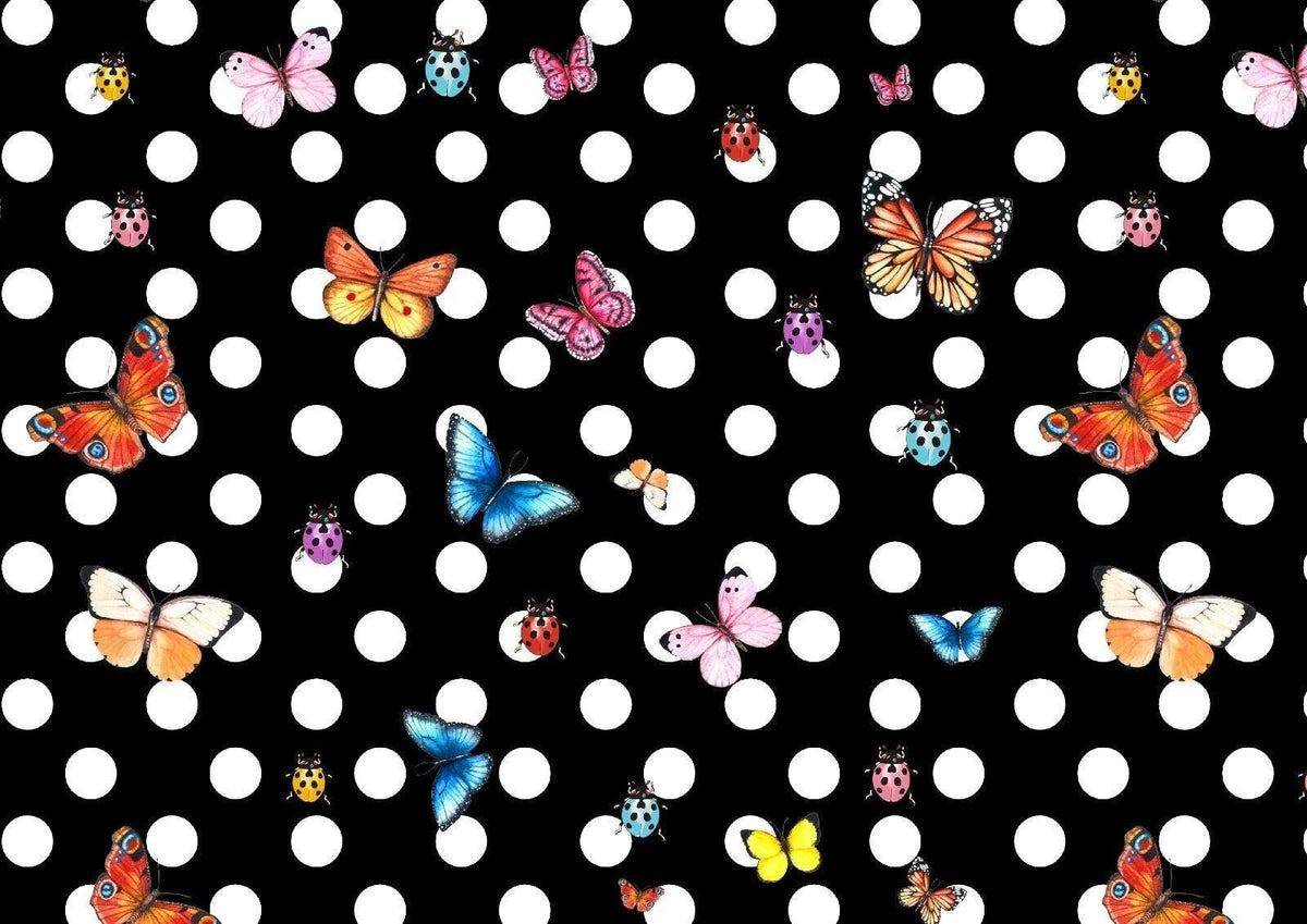 Black fabric with white polka dots featuring colorful butterfly and ladybug patterns for sewing projects.