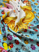 Colorful butterfly and polka dot print fabric with vibrant ladybugs on light blue background