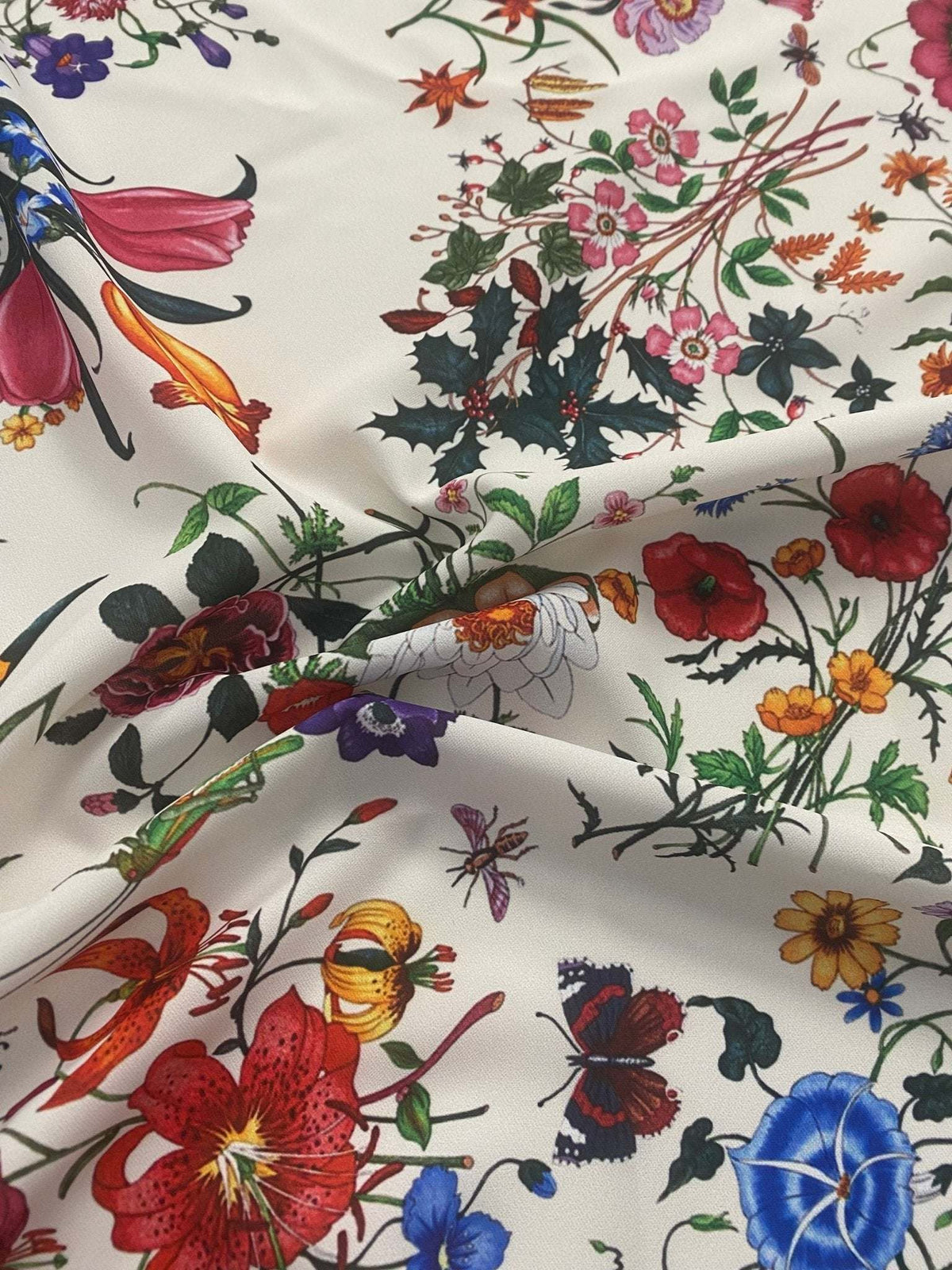 Cream floral botanical print fabric with colorful flowers and leaves on a cream background, soft and durable material.