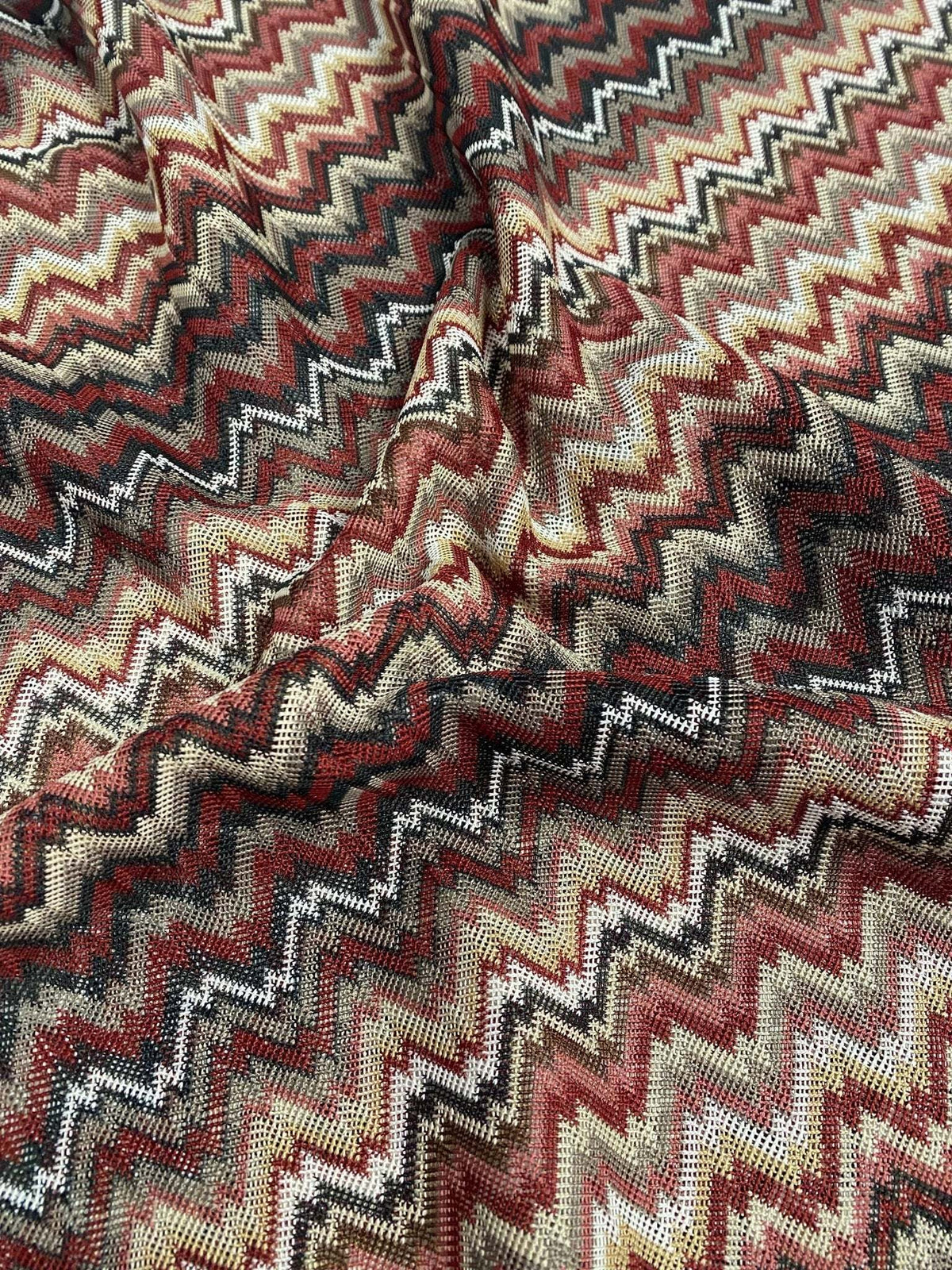 Earth tone zigzag woven mesh fabric in green and brown shades with textured knit pattern