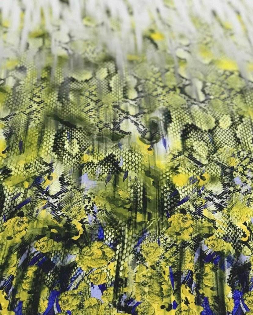 Close-up of green snake skin fabric with textured pattern and floral accents, fabric width 150cm