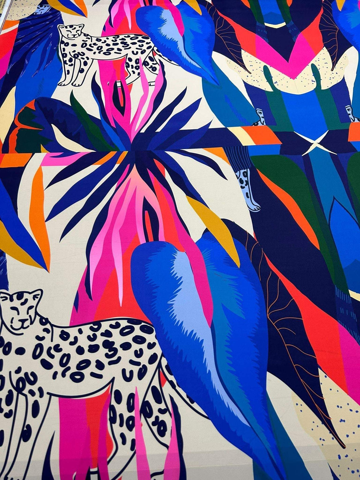Leopard and tropical patterned fabric with vibrant blue, pink, orange, and green leaves and leopard illustrations, 150cm width