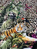 Leopard tropical leaf pattern fabric with jungle animals including a tiger, toucan, and monkey on leopard print background