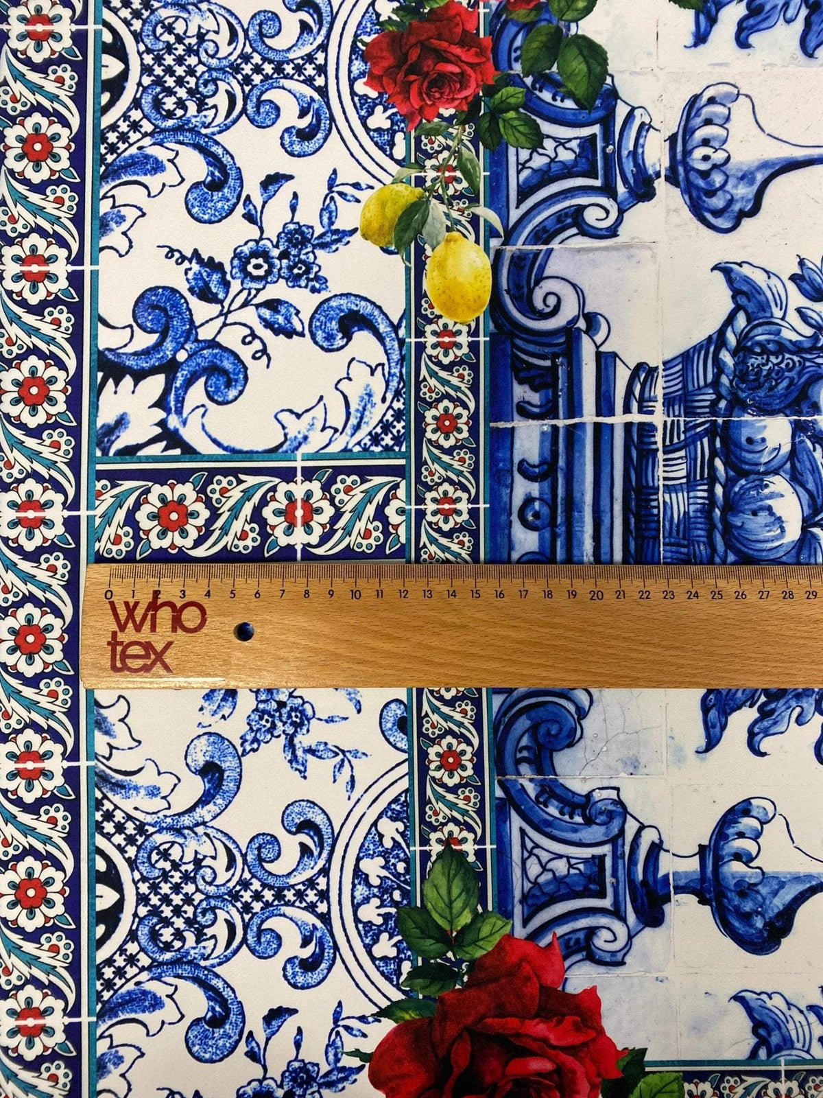 Majolica mosaic pattern Italian tile fabric with blue floral and ornamental designs and red rose accents.