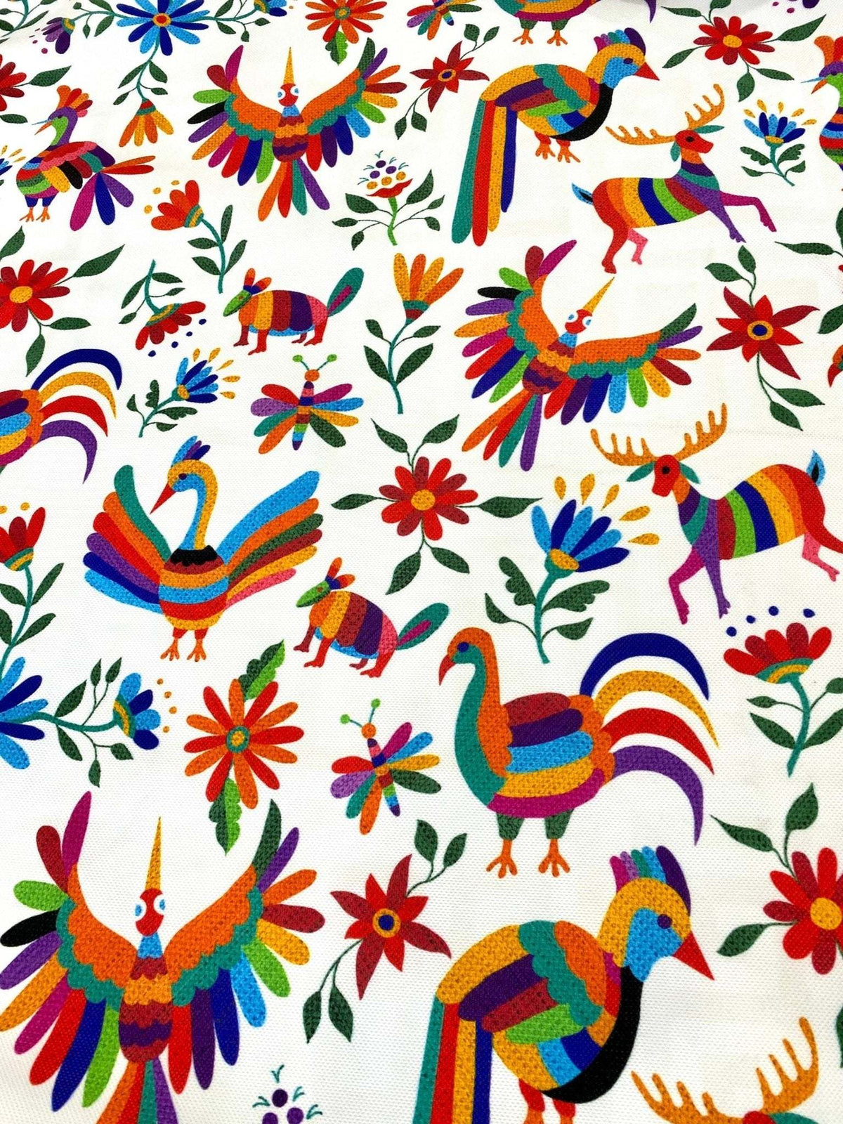 Colorful Otomi print fabric with vibrant birds, animals, and flowers for outdoor pillow upholstery.