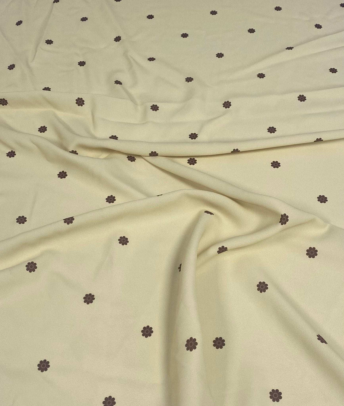 Minimal yellow fabric with small brown floral pattern on soft textured material