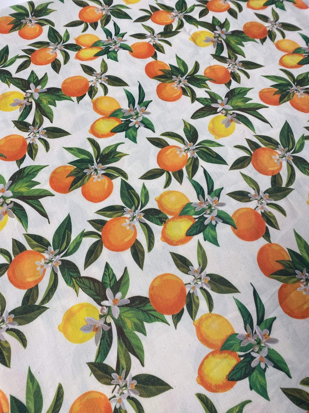 orange linen fabric with vibrant orange and yellow citrus fruit pattern and green leaves for crafting and home decor