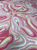 Pink and yellow psychedelic swirl print fabric with vibrant abstract design and smooth texture