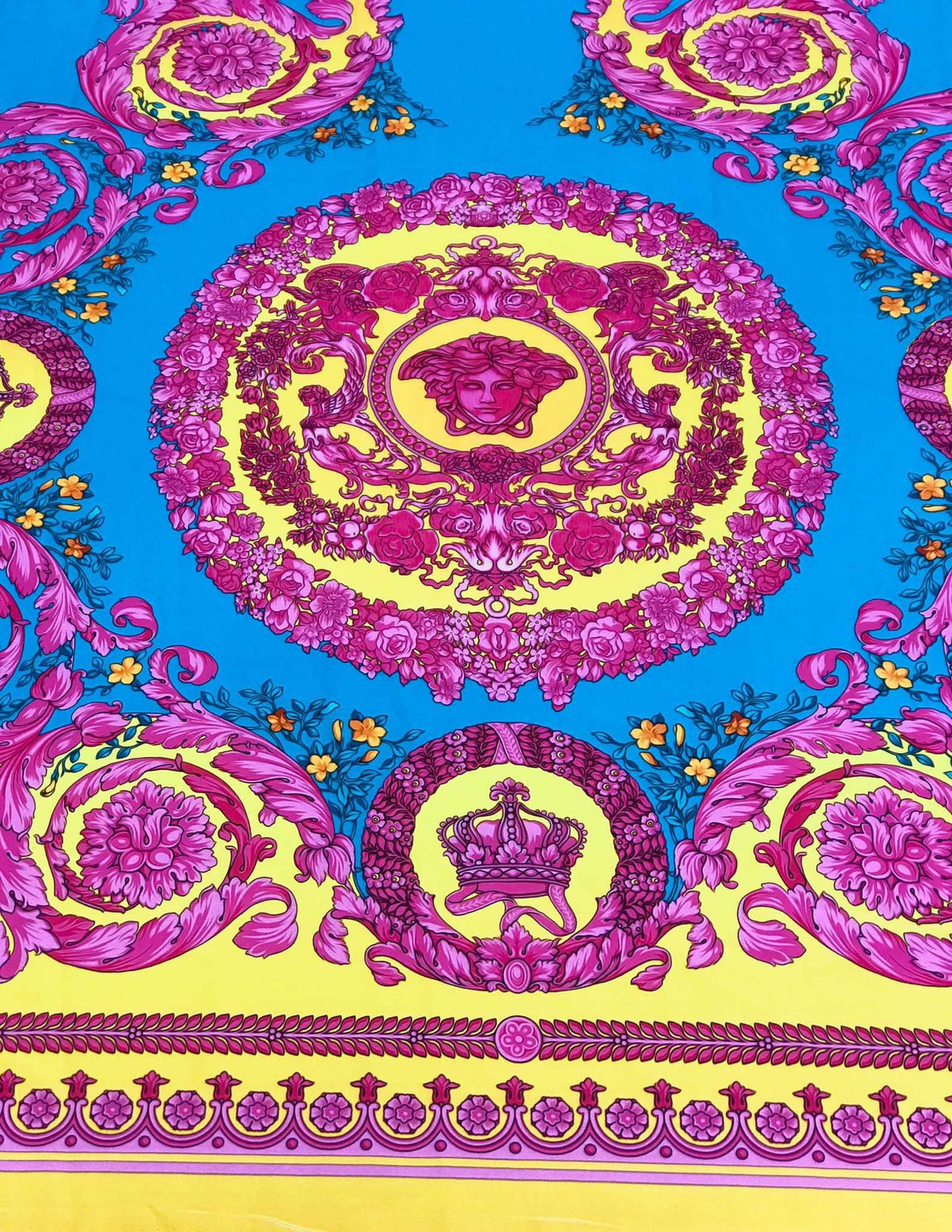 Pink Baroque silky fabric with intricate pink and gold baroque patterns on a vibrant blue and yellow background