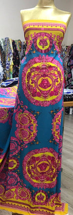 Pink Baroque Silky Fabric with vibrant pink and yellow baroque patterns on a teal background, displayed on a mannequin in a fabric store