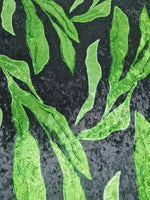 silky velvet fabric with green leaf pattern on black background