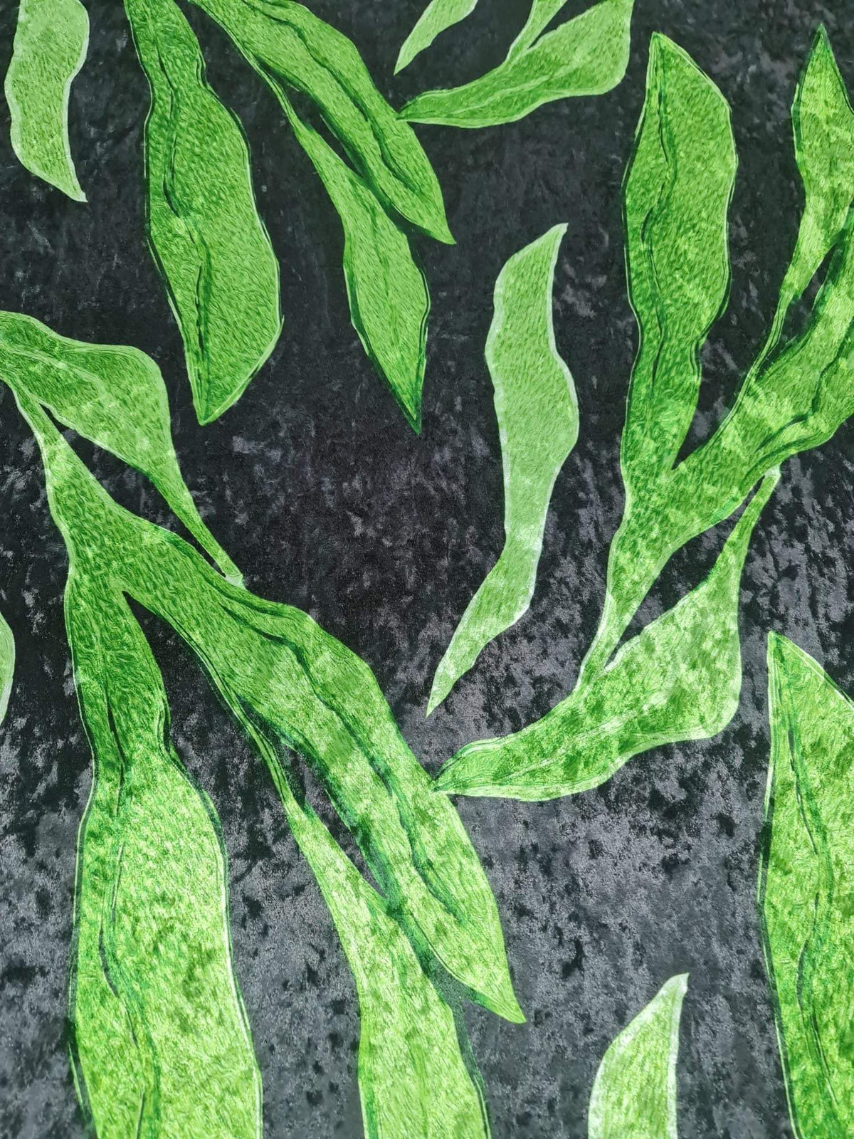 silky velvet fabric with green leaf pattern on black background