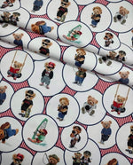 White upholstery fabric with playful digitally printed teddy bear pattern in various outfits and activities, suitable for outdoor use.