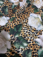 Floral and cheetah pattern fabric with white roses and green leaves on a cheetah print background
