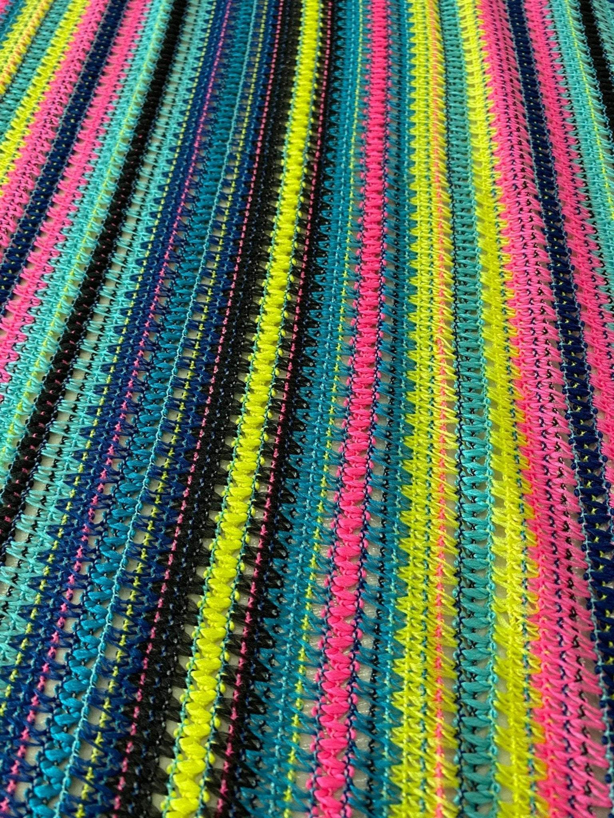 colorful zigzag knit jersey fabric with black, yellow, pink, and blue stripes in textured pattern