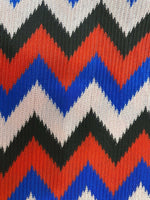 close-up of luxury zigzag knit jersey fabric in blue red black and pink with textured pattern