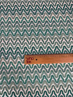 Zigzag mesh fabric in green tones with rhythmic knit pattern and ruler for scale